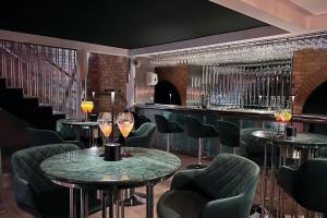 斯旺西摩根斯酒店的酒吧设有四张桌子和椅子,并配以酒杯