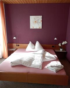 LotzwilHotel Restaurant Bad Gutenburg的一间卧室配有一张大床和紫色墙壁