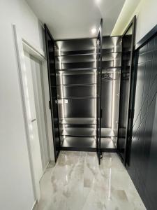 拉克塔希Apartmani Mila的步入式衣柜,带黑色和不锈钢门