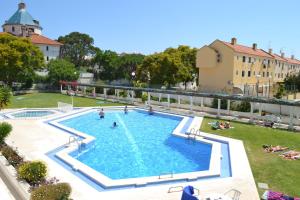 维拉摩拉加尔维图阿尔伽迪亚滨海公园公寓的一座大型游泳池,里面的人在院子里