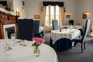 Chirnside奇尔旁厅酒店的用餐室配有2张带鲜花的桌子