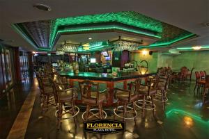 特古西加尔巴FLORENCIA PLAZA HOTEL的餐厅内的酒吧拥有绿色的灯光