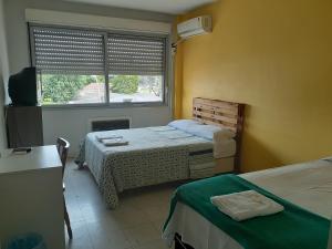 阿雷格里港Pousada Terra Sul的一间卧室设有两张床和窗户。