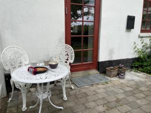 维比Vita og Pouls Gård - Guesthouse的门前的白色桌子和椅子