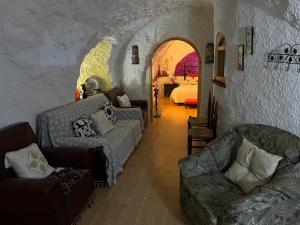 FontanarCasa Cueva La Fuente的带沙发的客厅和1间带1张床的房间