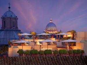 罗马Bio Hotel Raphael - Relais & Châteaux的一座带大教堂的建筑和一座带遮阳伞的建筑