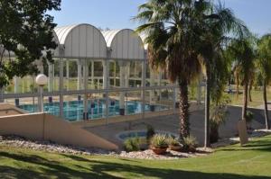凯撒利亚lasuita-exclusive suites ceserea-sunset suite的一座带游泳池和棕榈树的大型建筑