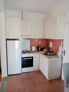 蒂瓦特Apartmani Bosco的厨房配有白色橱柜和白色冰箱。
