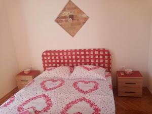 蒂瓦特Apartmani Bosco的一间卧室配有带心包的床罩