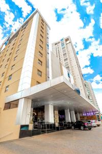 戈亚尼亚SJ Premium Hotels By Atlantica的一座大型建筑,前面设有停车场
