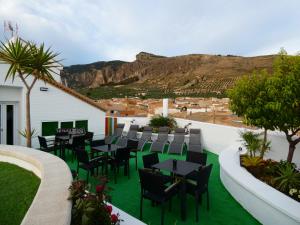 HuesaHotel Sierra de Huesa的一个带桌椅的庭院,背景是一座山。