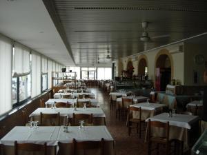 弗拉特基艾维奇坦皮酒店的一间设有白色桌椅和窗户的用餐室