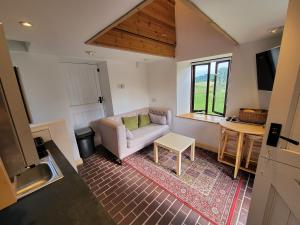 LlanfaenorCae Hedd Holiday Cottages in the heart of Monmouthshire的客厅配有沙发和桌子