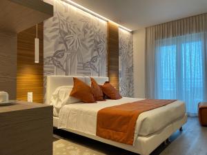 利多迪耶索罗奥罗拉酒店的一间卧室配有一张带橙色枕头的大床