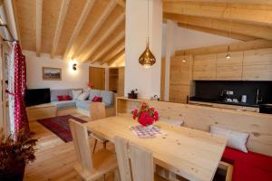 Vodo CadoreChalet del Capriolo的厨房以及带木桌的起居室。