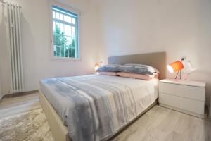 博洛尼亚Ghisello Luxury Guesthouse的白色的卧室设有床和窗户