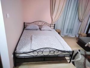 弗尔尼亚奇卡矿泉镇Apartman 1的一间卧室配有黑色床、白色床单和枕头