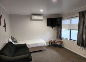 蒂阿瓦穆图ASURE阿尔伯特公园汽车旅馆的卧室配有床、椅子和窗户。