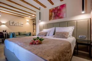 斯普利特Old Spalatrum Luxury Rooms的一间卧室配有一张带鲜花的大床