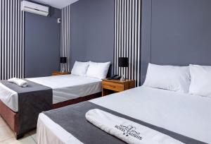 皮乌拉Hotel Taurus的酒店客房,配有两张带白色床单的床