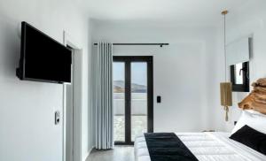 米克诺斯城BLACK AND WHITE VILLAS FTELIA - MYKONOS的一间卧室配有一张床和一台平面电视