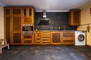 辛方伊什Douro Senses - Nature House的厨房配有木制橱柜和洗衣机。