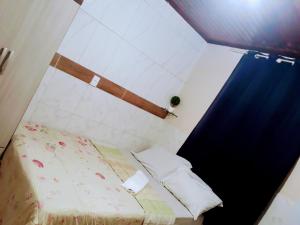 马瑙斯RESIDENCIAL OLIVEIRA的小房间,配有床和蓝色窗帘