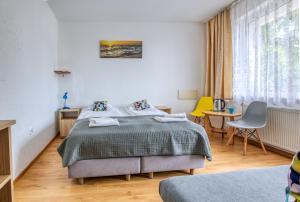 弗瓦迪斯瓦沃沃Ośrodek Wypoczynkowy CHAMPION的一间卧室配有一张床、一张桌子和一张黄椅