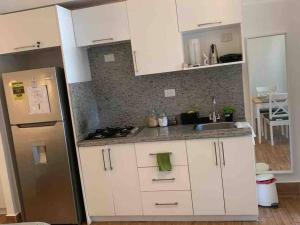 蓬塔卡纳Espectacular Apartamento En Tanama Cap Cana的厨房配有白色橱柜和不锈钢冰箱