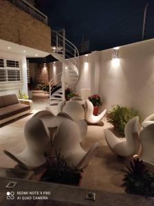 加拉加斯Una casa con vistas en Caracas的一群白色椅子在庭院里过夜