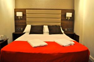 伦敦古德伍德酒店的一间卧室配有一张大床和两条毛巾
