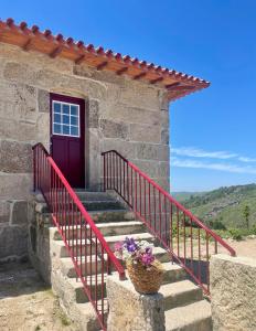 BrufeCasa do Afonso的石头房子,有红色的门和楼梯