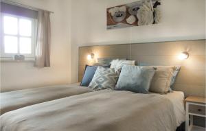 Loon op ZandOns Binkje的卧室配有带枕头的大床和窗户。