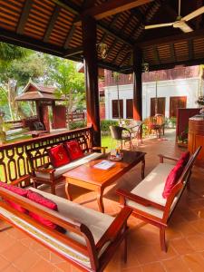 琅勃拉邦Luang Prabang Villa Sirikili River View的门廊上设有带沙发和桌子的庭院