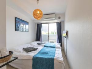 大阪Tabist Gloire Osaka的一间卧室配有一张带蓝色毯子的床