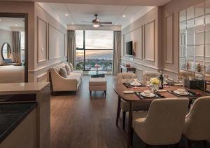 岘港Luxury Apartment in Sheraton Building with Ocean View的厨房以及带桌椅的起居室。