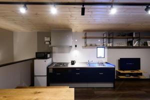 佐世保Rakuten STAY HOUSE x WILL STYLE Sasebo 102的厨房配有炉灶和白色冰箱。