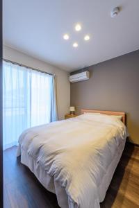 佐世保Rakuten STAY HOUSE x WILL STYLE Sasebo 104的卧室设有一张白色大床和一扇窗户。
