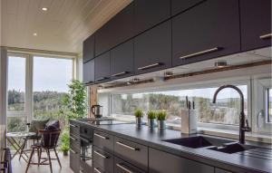 SøndeledCozy Home In Sndeled With House Sea View的一间厨房,配有黑色橱柜和大窗户