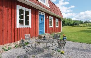 HolmsjöBeautiful Home In Holmsj With Lake View的红色建筑前的桌椅