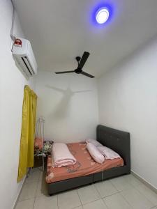 峇六拜NORISH HOMESTAY的一间卧室配有一张带粉红色枕头的床和吊扇。