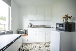 RanfurlyRanfurly Motels的厨房配有白色橱柜、水槽和微波炉