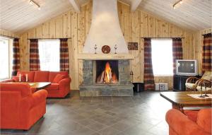 海姆瑟达尔Skarsnuten的客厅设有壁炉和橙色家具。