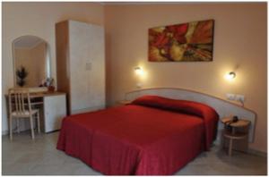 贝内文托维托瑞亚酒店的一间卧室配有红色的床和一张书桌