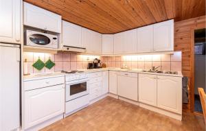 桑纳讷3 Bedroom Amazing Home In Sandane的厨房配有白色橱柜和木制天花板