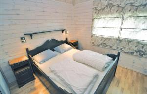斯朱森3 Bedroom Stunning Home In Sjusjen的一间卧室配有一张带白色床单的床和一扇窗户。