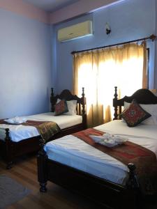 万荣索泰餐厅旅馆的带窗户的客房内的两张床