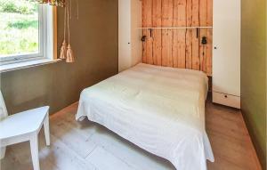 SvanesundNice Apartment In Svanesund With House Sea View的一间小卧室,配有白色的床和窗户
