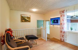 AmbjörnarpAwesome Home In Ambjrnarp With Wifi的一间设有婴儿床、椅子和电视的房间