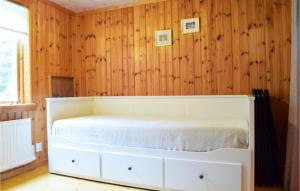韦斯特维克Stunning Home In Vstervik With Kitchen的配有木墙的客房内的一张白色床